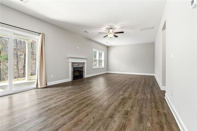 unfurnished living room featuring dark wood finished floors, a fireplace, visible vents, a ceiling fan, and baseboards