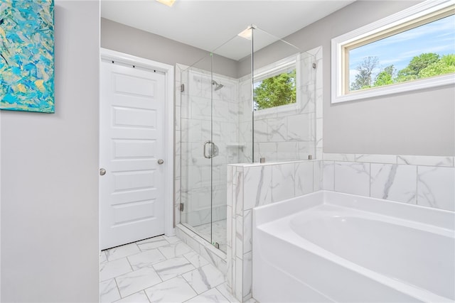 bathroom featuring marble finish floor, a bath, and a marble finish shower