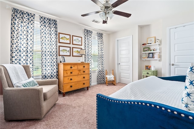 carpeted bedroom featuring baseboards, multiple windows, a ceiling fan, and visible vents