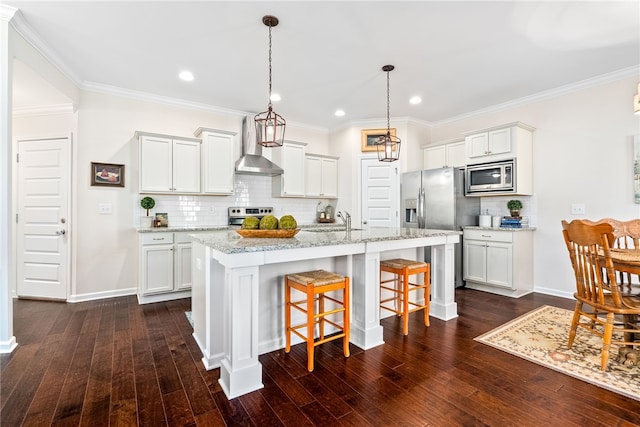 kitchen featuring wall chimney range hood, a sink, stainless steel appliances, recessed lighting, and decorative backsplash
