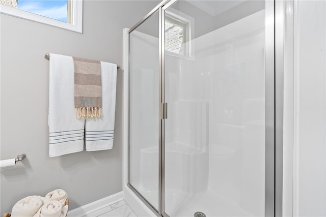 full bath featuring baseboards, marble finish floor, and a stall shower