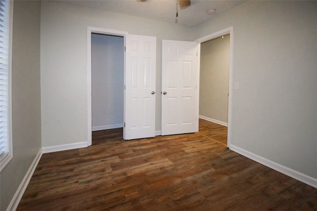 unfurnished bedroom with a closet, dark hardwood / wood-style floors, and ceiling fan