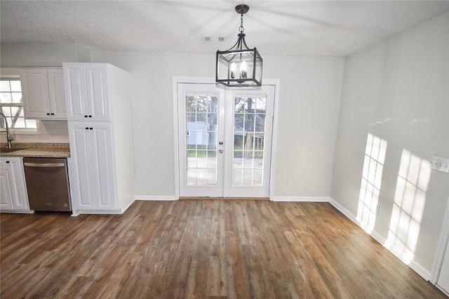 unfurnished dining area featuring french doors, a chandelier, dark hardwood / wood-style floors, and sink