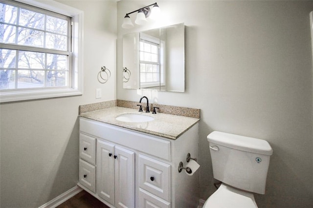 bathroom with vanity, toilet, and plenty of natural light