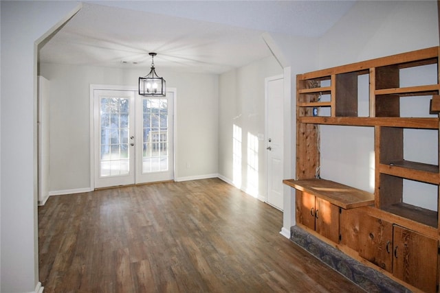 interior space with a chandelier, dark wood-type flooring, and french doors