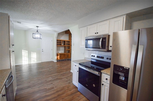 kitchen with white cabinets, stainless steel appliances, tasteful backsplash, and hanging light fixtures