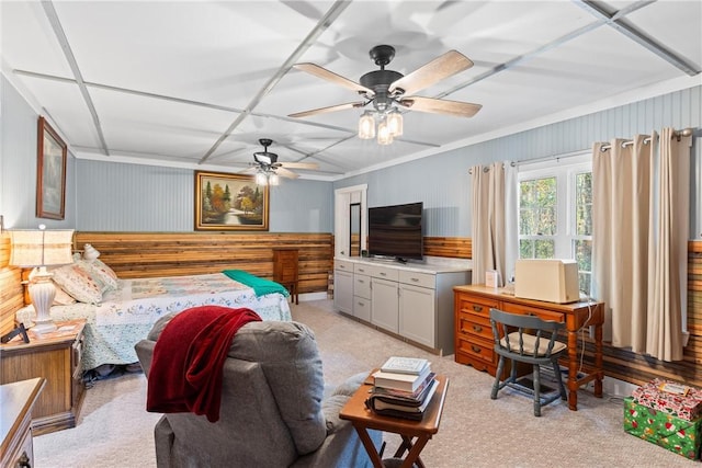 carpeted bedroom featuring ceiling fan and wooden walls