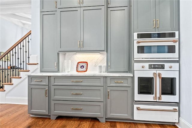 2051 Moores Mill Rd Unit K, Auburn, AL 36830 - kitchen featuring gray cabinetry, double oven, dark wood-style floors, light countertops, and decorative backsplash
