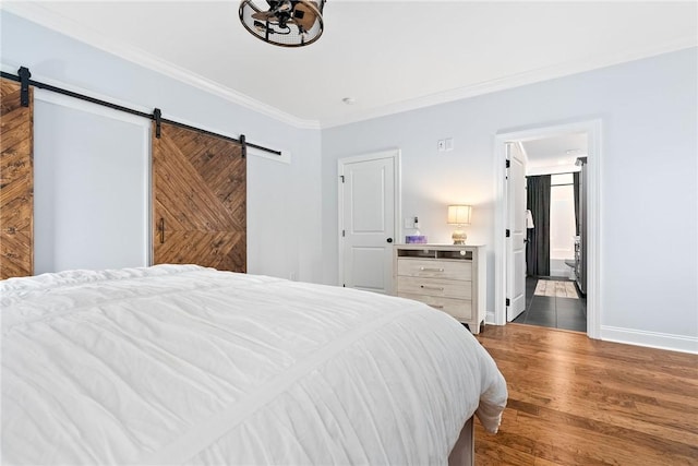 2051 Moores Mill Rd Unit K, Auburn, AL 36830 - bedroom with a barn door, crown molding, dark wood-style flooring, and ensuite bathroom