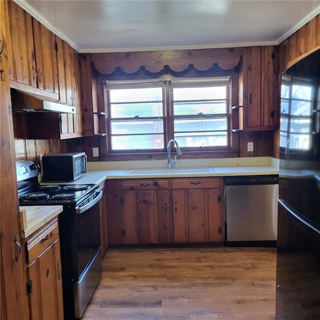 kitchen with sink, light hardwood / wood-style flooring, crown molding, and black appliances