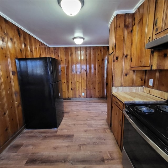 kitchen featuring wooden walls, light hardwood / wood-style flooring, ornamental molding, and black appliances