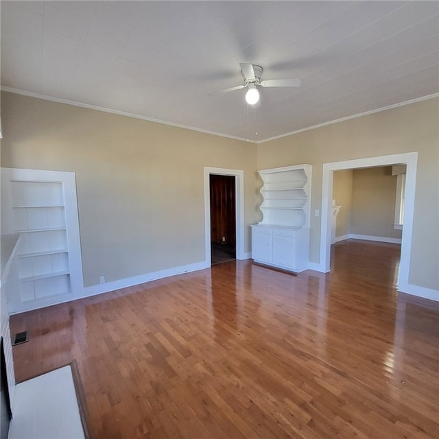 unfurnished living room with hardwood / wood-style flooring, ceiling fan, built in features, a fireplace, and ornamental molding