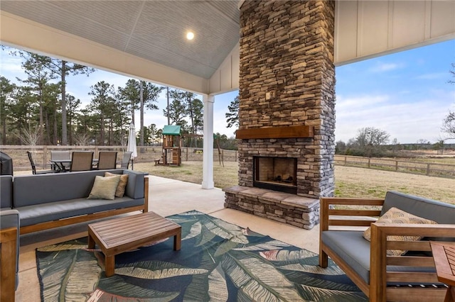 view of patio / terrace featuring a playground and an outdoor living space with a fireplace