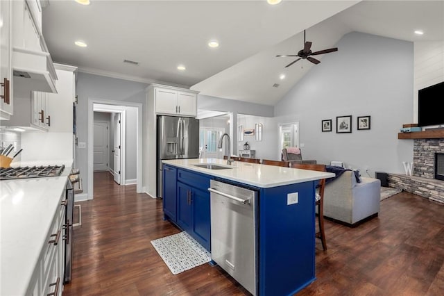 kitchen featuring a center island with sink, sink, a kitchen breakfast bar, white cabinets, and blue cabinets