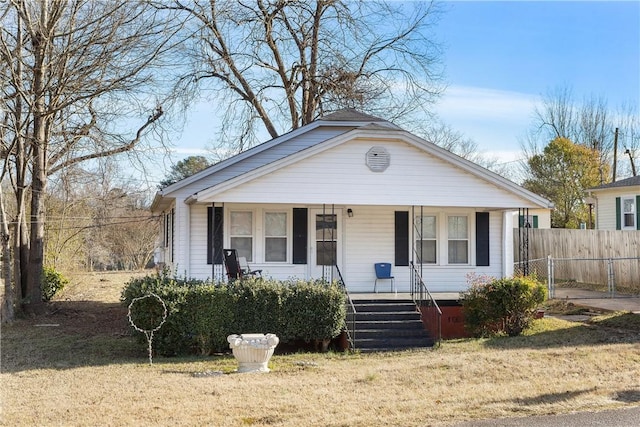 view of front of home with covered porch and a front lawn