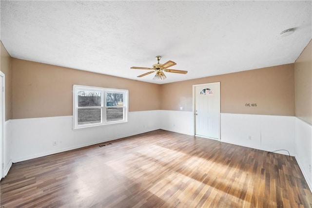 unfurnished room featuring ceiling fan, a textured ceiling, and wood-type flooring