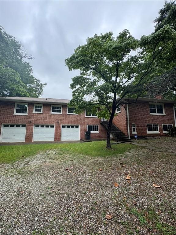 314 N 5th St, Opelika, AL 36801 - rear view of property with an attached garage, brick siding, and driveway