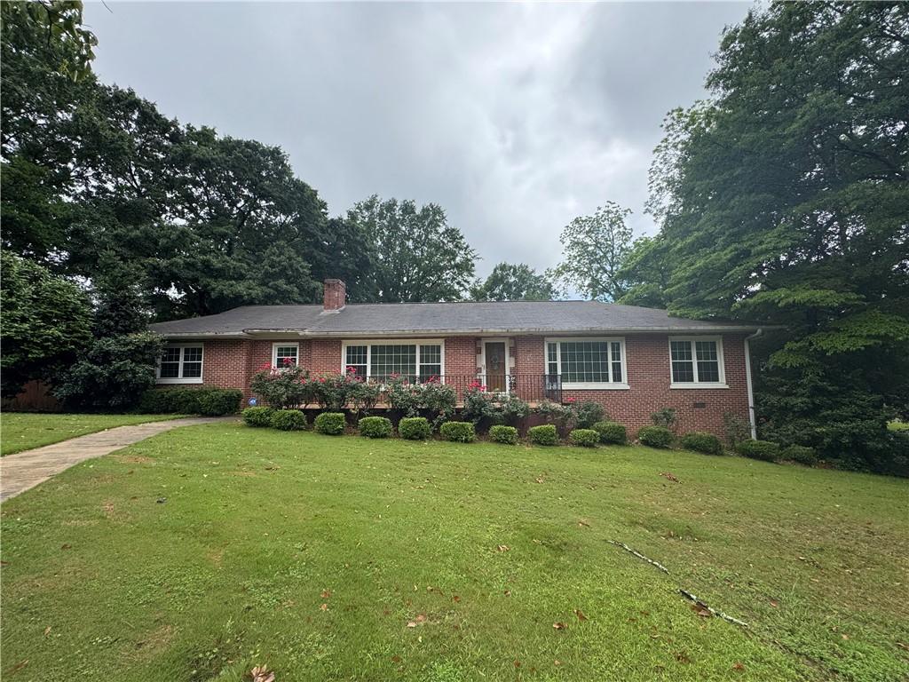 314 N 5th St, Opelika, AL 36801 - ranch-style house featuring brick siding, a front lawn, and a chimney