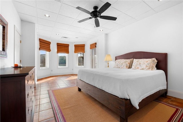 bedroom with light tile patterned flooring, a paneled ceiling, and ceiling fan