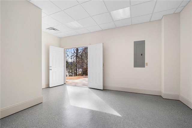 unfurnished room featuring a drop ceiling and electric panel