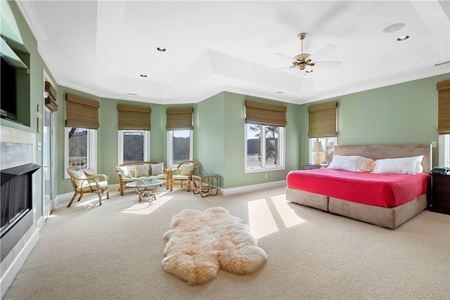 bedroom with crown molding, light colored carpet, ceiling fan, and a tray ceiling