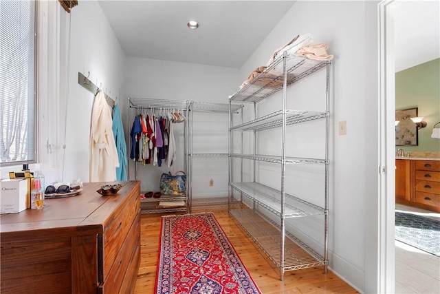 walk in closet with light hardwood / wood-style floors