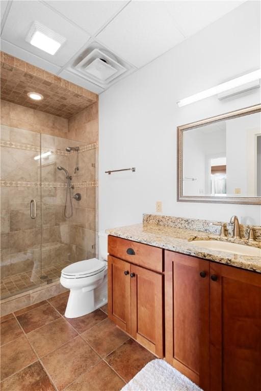 bathroom featuring toilet, vanity, and a shower with door