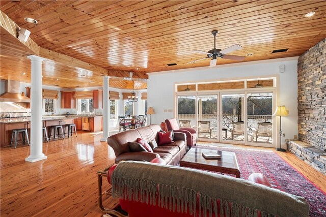 kitchen featuring wall chimney range hood, wood ceiling, stainless steel appliances, a center island, and a kitchen bar