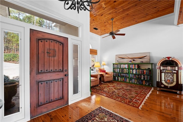 foyer featuring wood-type flooring, a chandelier, high vaulted ceiling, and wooden ceiling