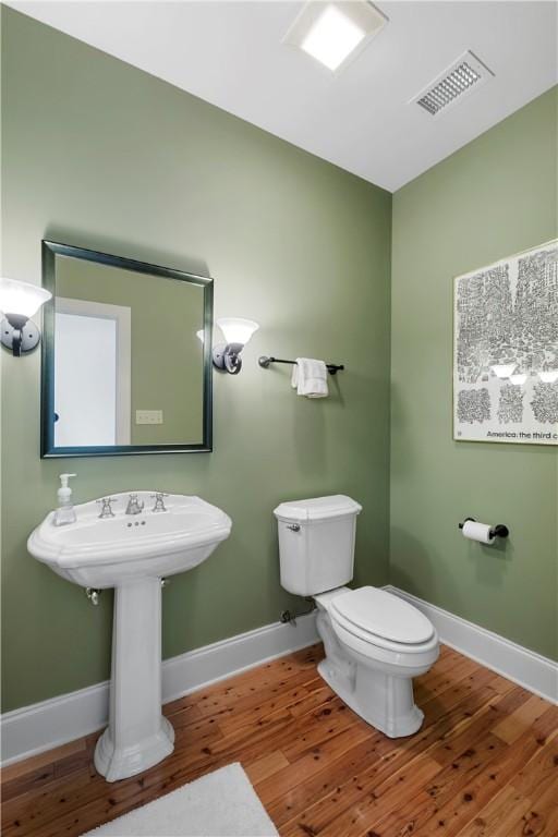 bathroom with toilet and hardwood / wood-style floors