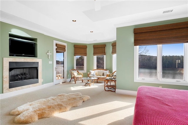 carpeted bedroom with access to outside, a tile fireplace, and a water view