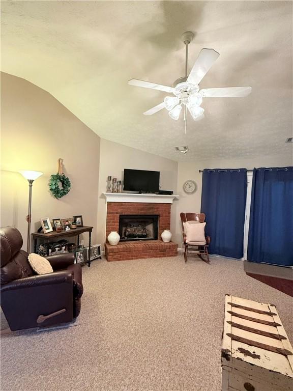 living room featuring a ceiling fan, lofted ceiling, a brick fireplace, and carpet floors