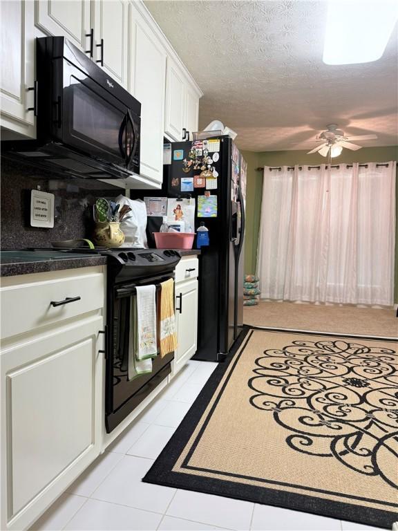 kitchen with ceiling fan, light tile patterned flooring, white cabinetry, black appliances, and dark countertops