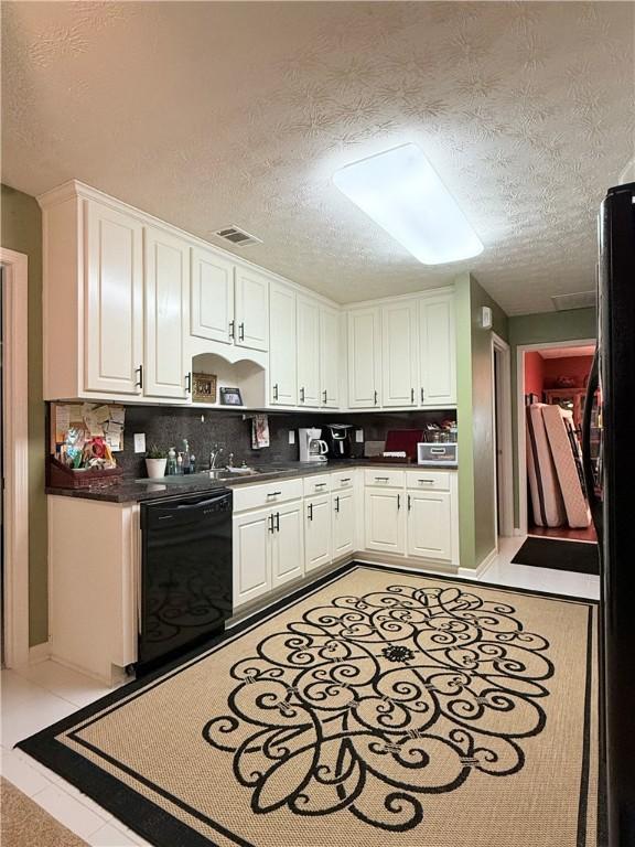 kitchen featuring a textured ceiling, black appliances, visible vents, white cabinetry, and dark countertops