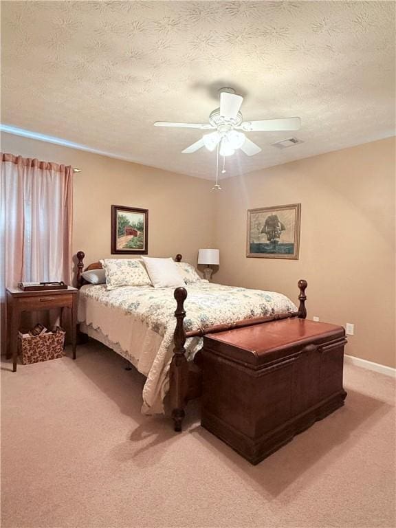 bedroom with light colored carpet, a textured ceiling, ceiling fan, and visible vents