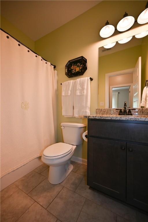 261 Woodward Way, Auburn, AL 36832 - full bathroom featuring toilet, tile patterned floors, vanity, baseboards, and curtained shower