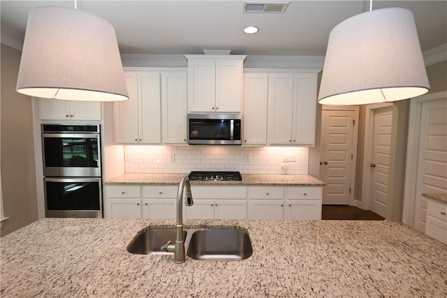 261 Woodward Way, Auburn, AL 36832 - kitchen featuring appliances with stainless steel finishes, a sink, white cabinets, decorative backsplash, and crown molding