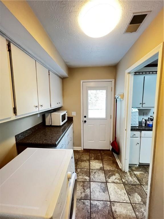 1128 Overwood Pl, Auburn, AL 36830 - washroom featuring washer / dryer, a textured ceiling, and stone finish flooring
