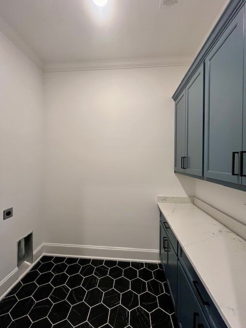 laundry room featuring electric dryer hookup, crown molding, and cabinets