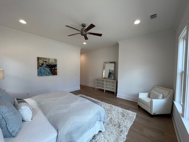 bedroom with ornamental molding, dark wood-type flooring, and ceiling fan