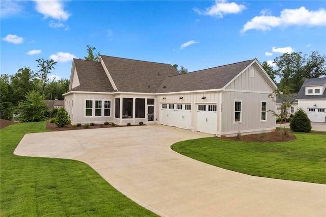 rear view of house featuring a garage and a lawn