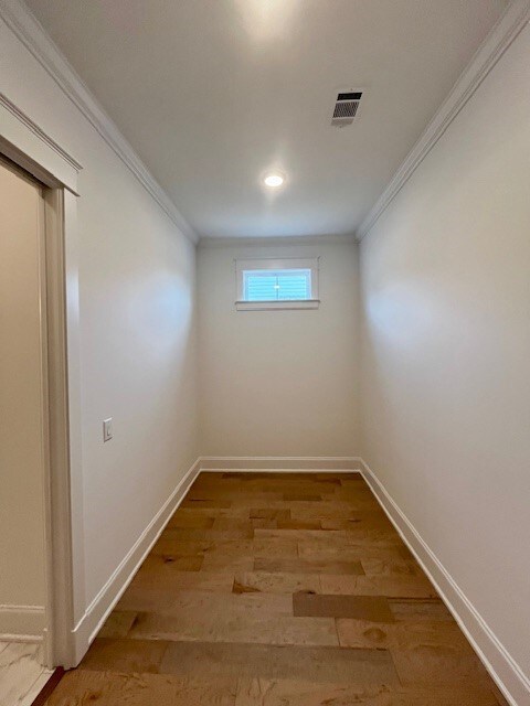 spare room featuring hardwood / wood-style flooring and ornamental molding