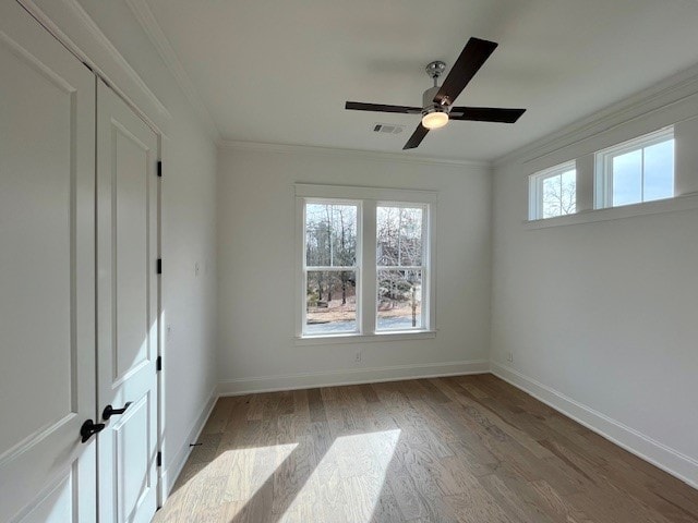 unfurnished bedroom with crown molding, ceiling fan, light hardwood / wood-style floors, and a closet