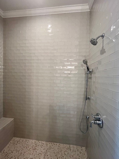 bathroom featuring ornamental molding and tiled shower