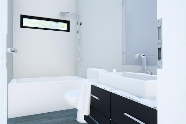 bathroom featuring a washtub, wood-type flooring, vanity, and toilet