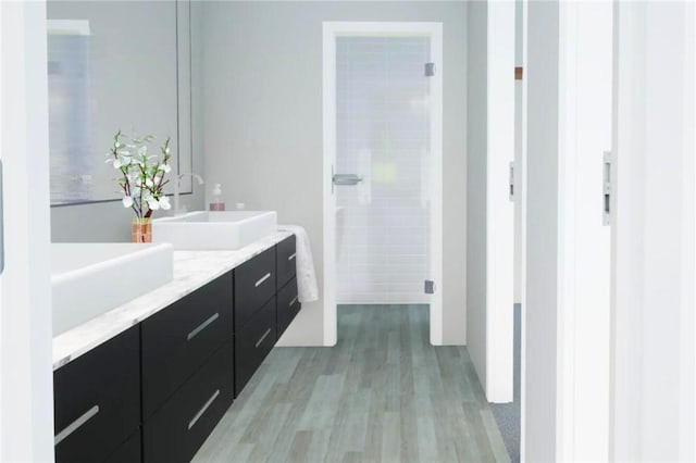 bathroom featuring hardwood / wood-style floors, vanity, and walk in shower