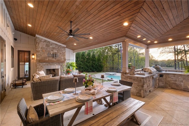 view of patio featuring exterior kitchen, a grill, outdoor dining area, ceiling fan, and an outdoor living space with a fireplace