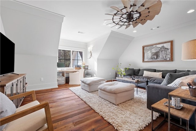 living room with a ceiling fan, ornamental molding, visible vents, wood finished floors, and baseboards
