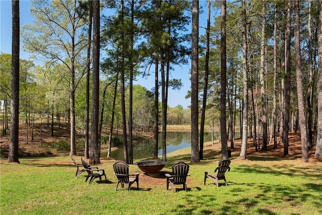 view of home's community featuring a water view, a yard, and a fire pit