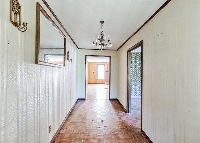 corridor featuring parquet floors, a chandelier, and ornamental molding